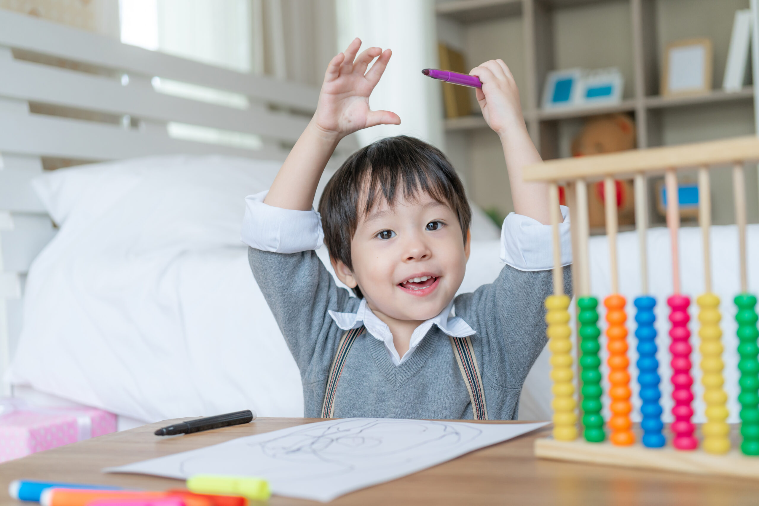 little cute boy proud when he finish drawing with happiness raised two hands his head smile scaled